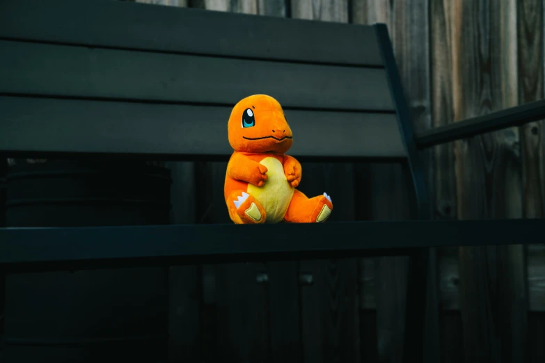 the stuffed toy is sitting by a fence