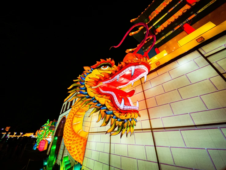 a dragon statue is lit up by colorful lights