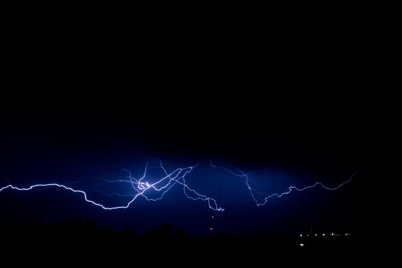 many bright blue electric wires are above some trees