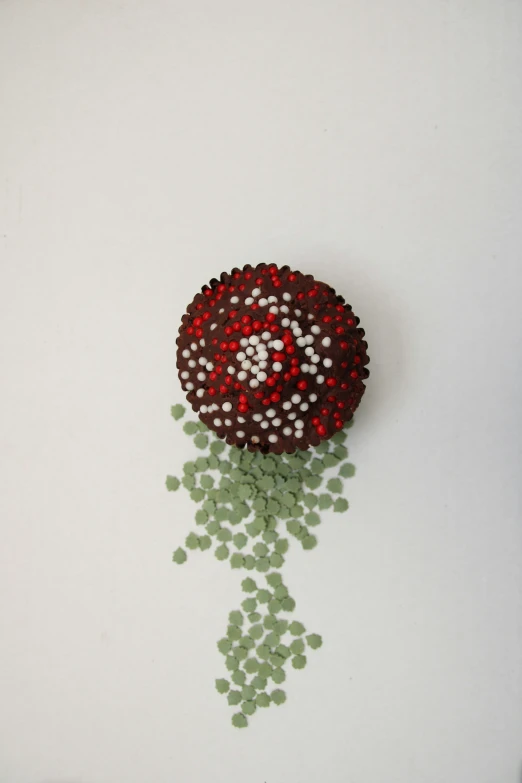 a flower made out of beads and some green pieces