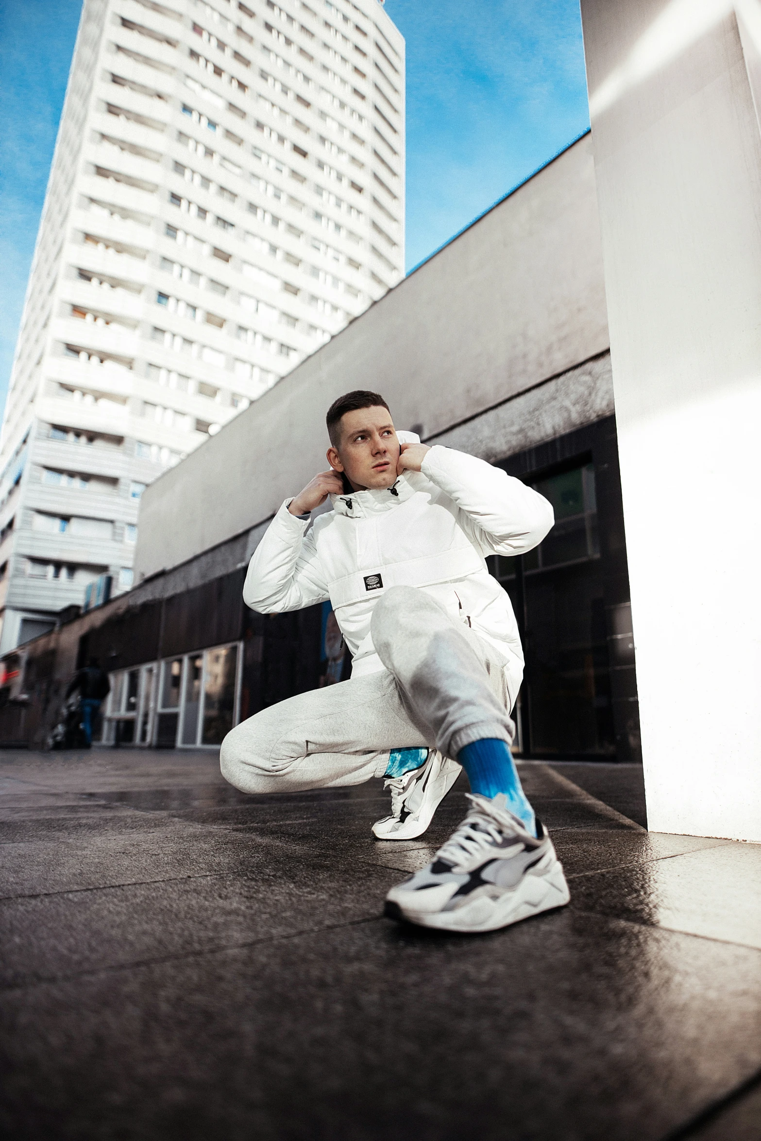 a man is leaning against the wall wearing his running shoes