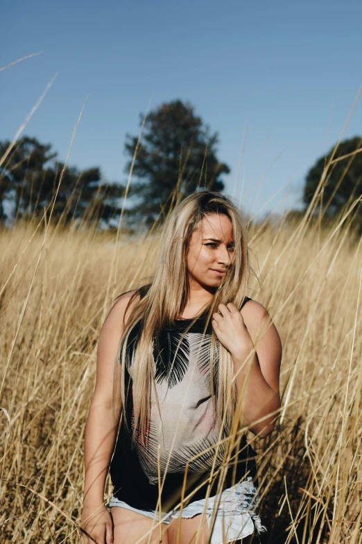 young women standing in a field of tall dry grass