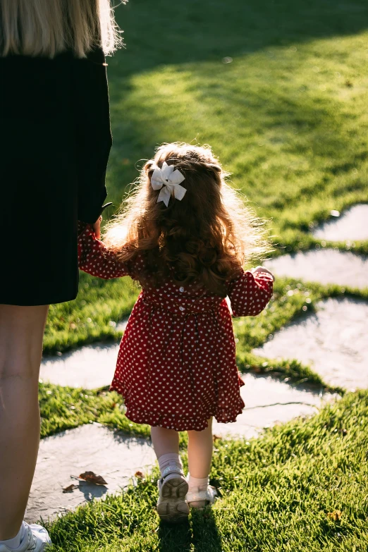 an image of a little girl holding her mother's hand