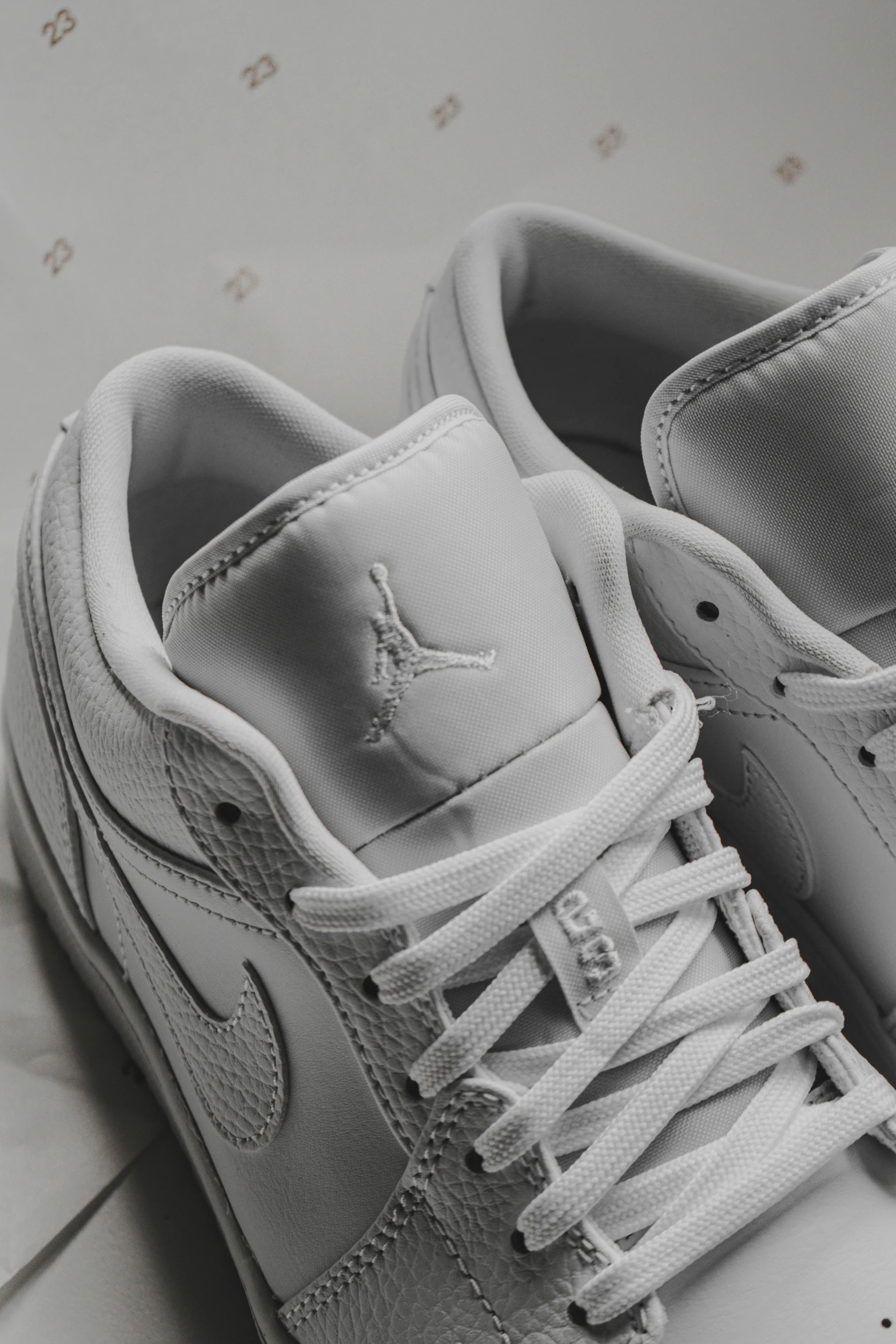 a pair of white sneakers sitting on top of a white counter