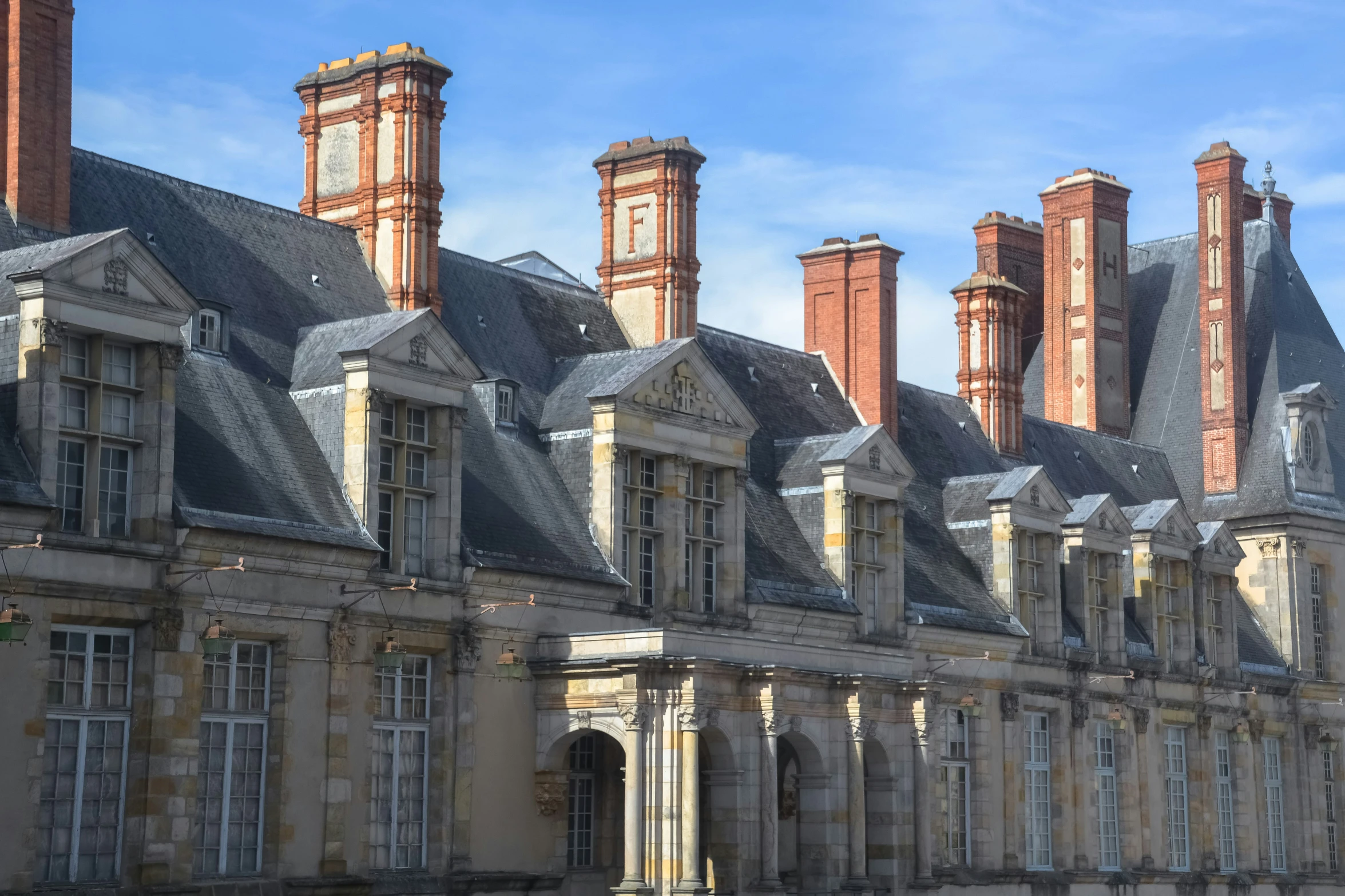 old french building with towers under a blue sky