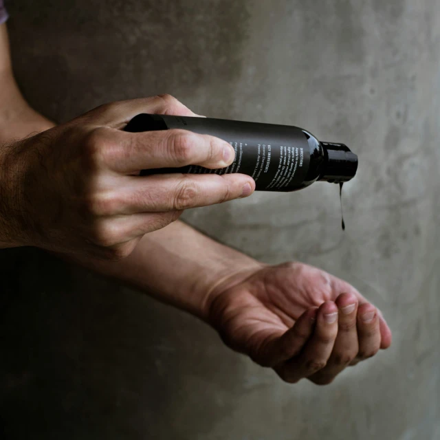 a person with their hand in the air with a bottle