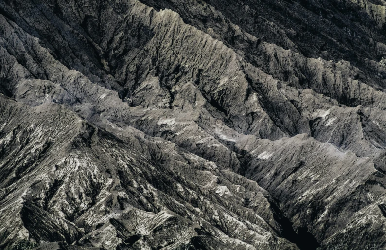 a black and white view of mountains and a plane