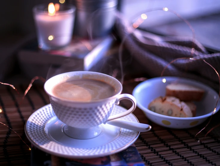 the small bowl is on the table with a cup of coffee