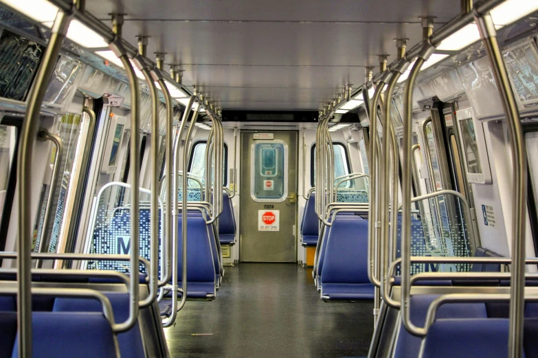 the inside of an empty train car has empty benches