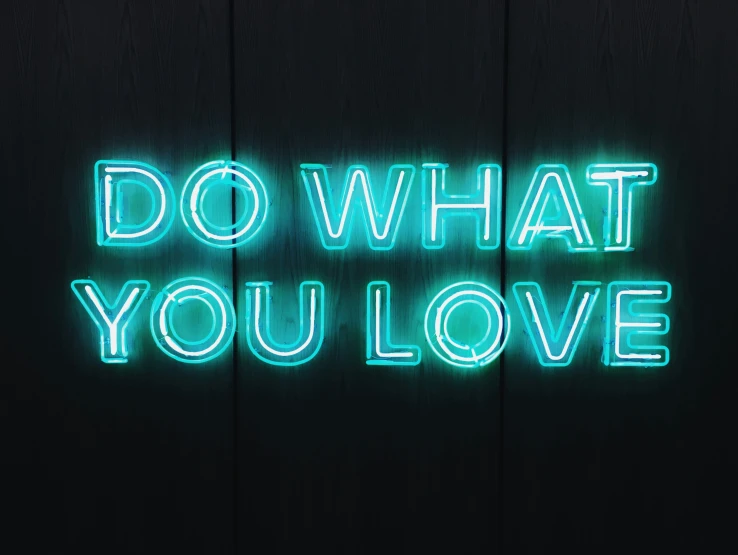 a wall with a neon sign that reads do what you love
