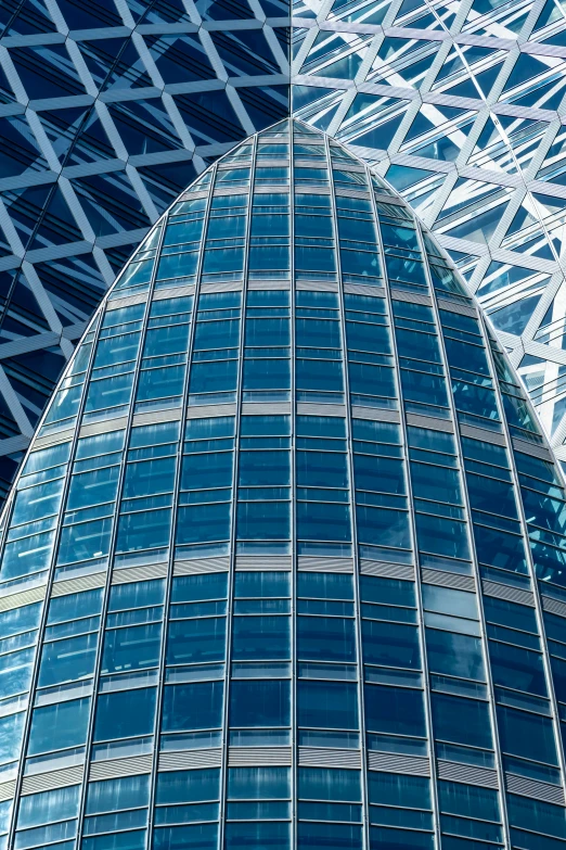 the large blue glass building has several angles on it