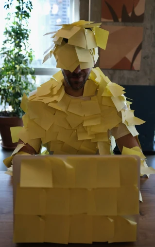a man made out of pieces of yellow paper