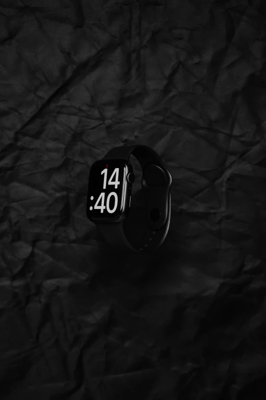 a watch showing the time sitting on top of a cloth covered table