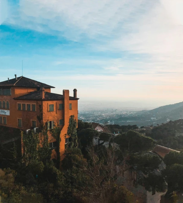 an apartment building perched on a hill overlooking the city