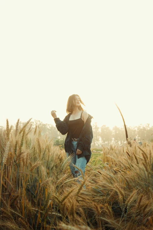 a woman standing in a field with some birds