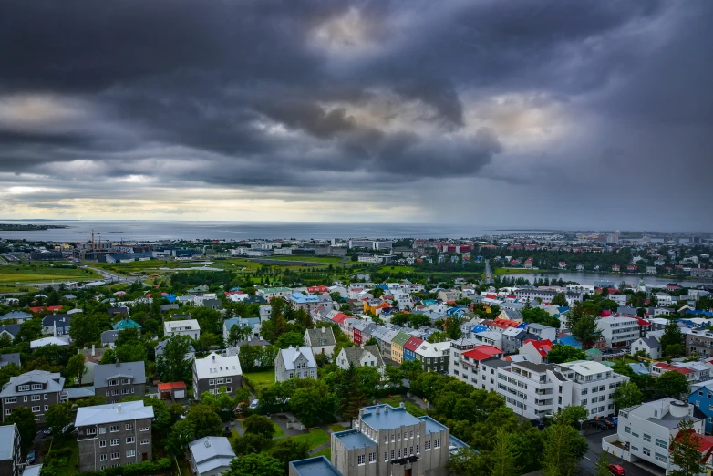 a cloudy sky over a town and the water