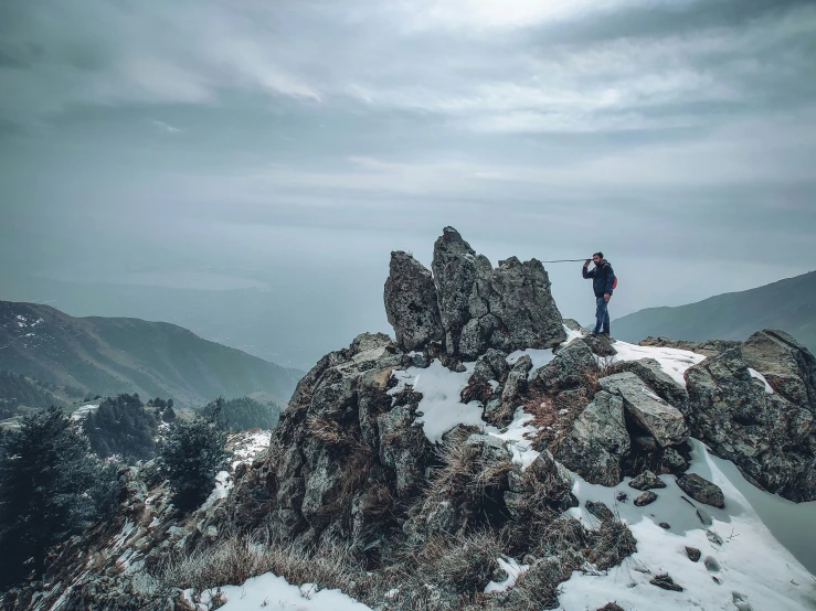 a person standing on top of a mountain surrounded by snow