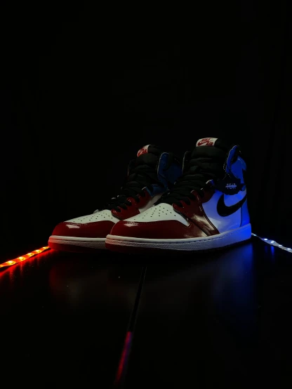 a pair of sneakers sitting on a black floor