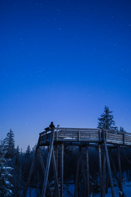 a night sky is illuminated by the stars over a wooden walkway