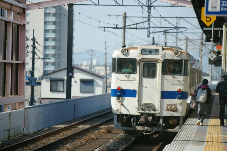 a train pulls into a station with passengers on either side