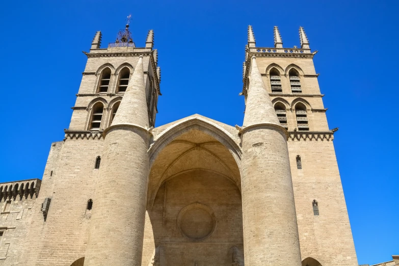 two ancient gothic buildings with towers in a blue sky