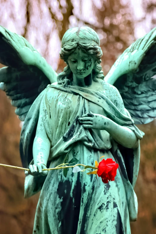 the statue is holding a rose that's been placed near her