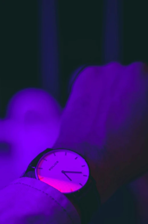 a hand is holding a bright pink wrist watch