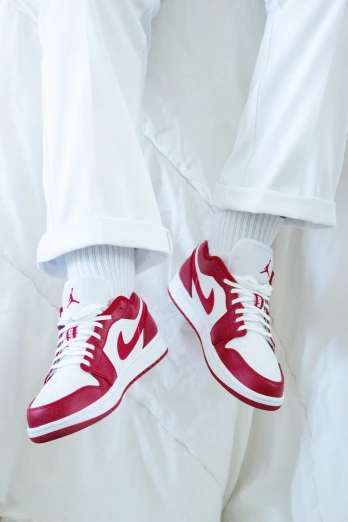 red nike shoes sitting on a white sheet