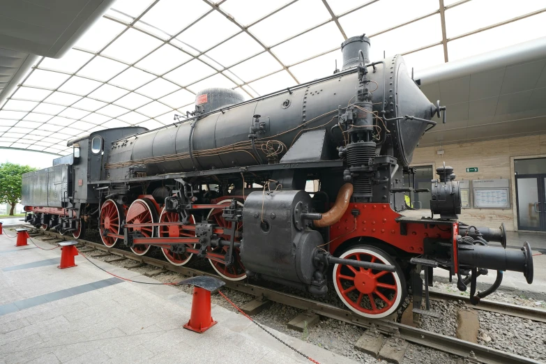 an old locomotive sits on the tracks in front of a walkway