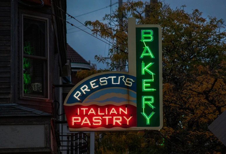 a bakery sign and neon signs on the outside of a building