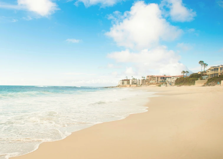 a view of a beach, with a few houses in the background