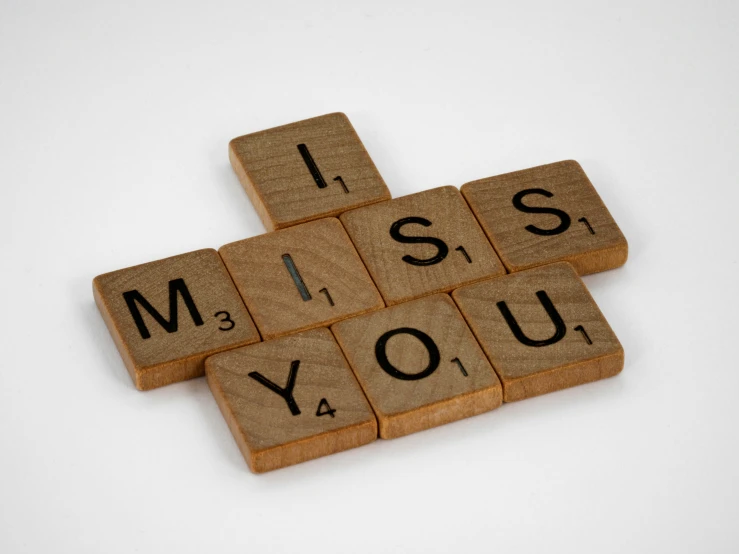 a couple of scrabble tiles that spell out miss you