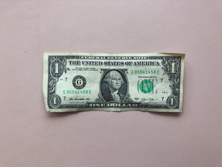 money laying on top of a pink surface