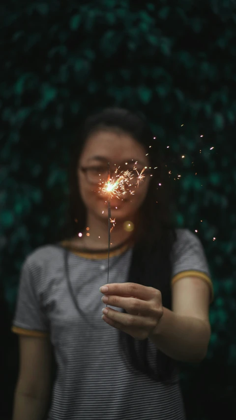 a woman holding a sparkler in her hands