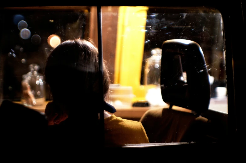 a woman sitting in the back seat of a bus