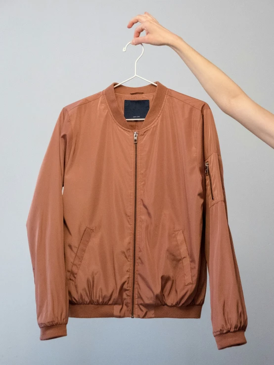 a brown jacket hanging on a white hanger