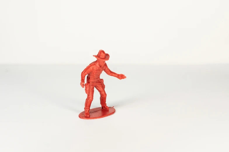 a man in red figurine standing on white background
