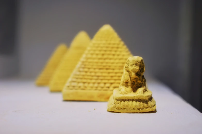 a group of different sized gold pyramids on a table