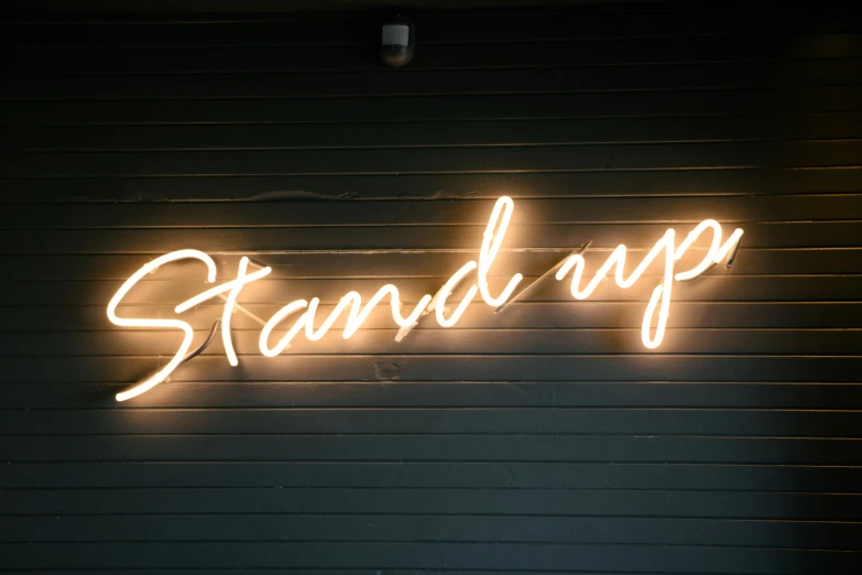 the word standup is illuminated with bright lights