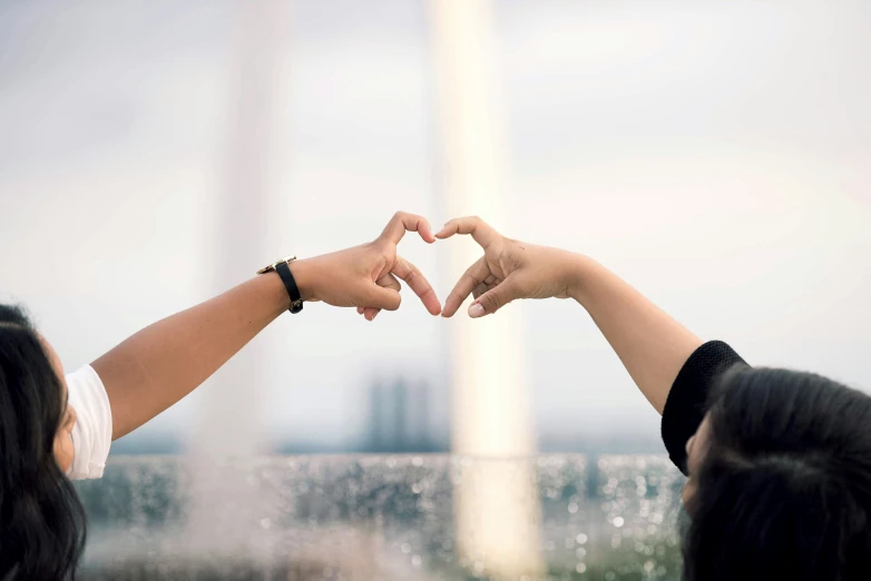 two people making a heart with their hands