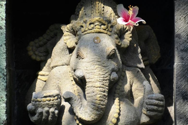 there is a statue with an elephant holding a flower