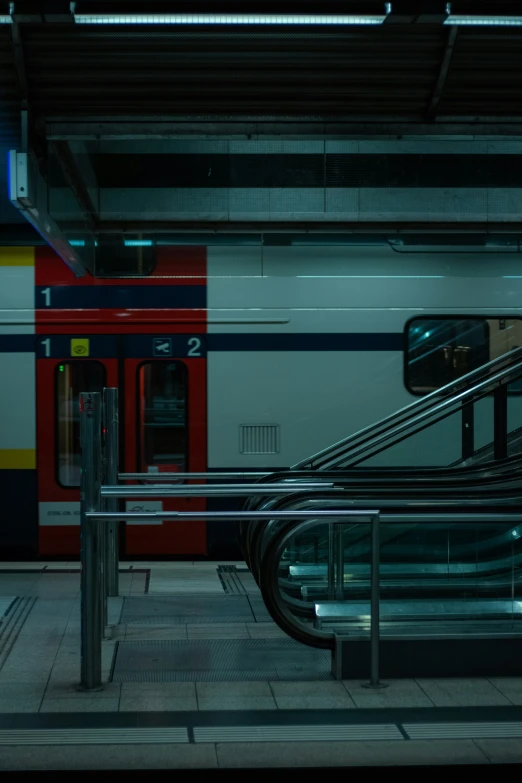 an empty subway station with a metal rail