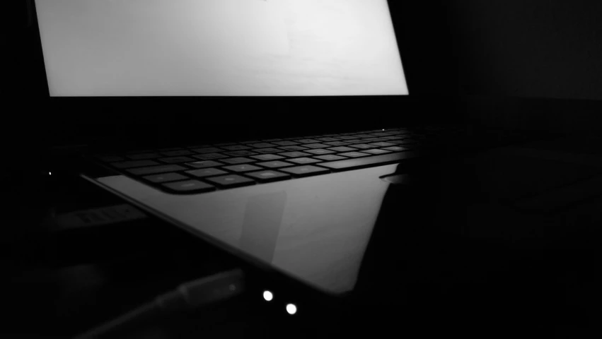 a laptop computer in the dark with a monitor