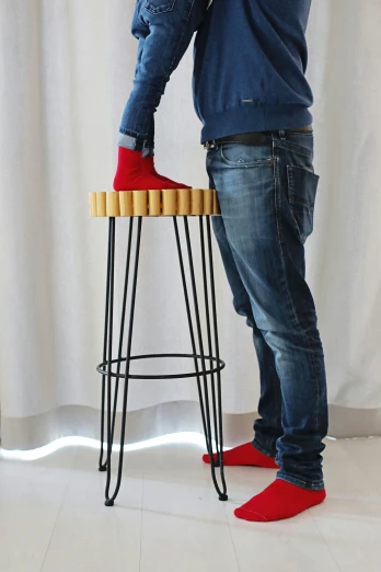 the man is using red shoes on his stool
