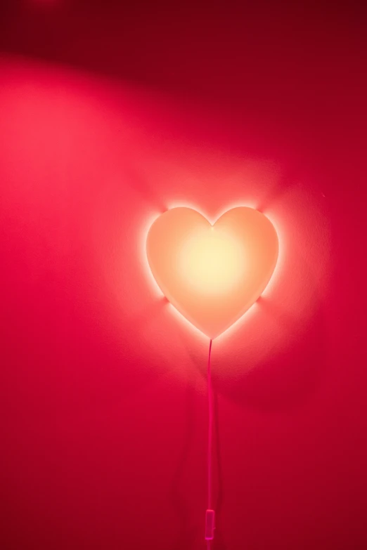 red light shines in the middle of a heart shaped object