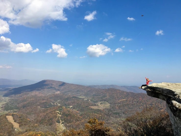 a person sitting on top of a mountain overlooking mountains