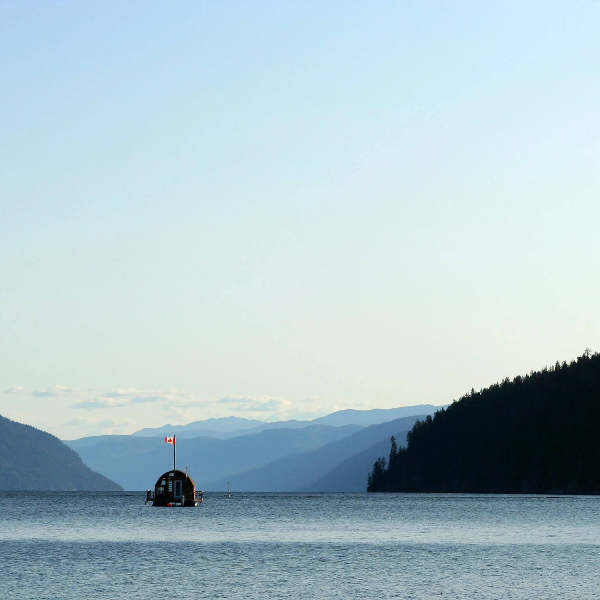 a small boat floating across a large body of water