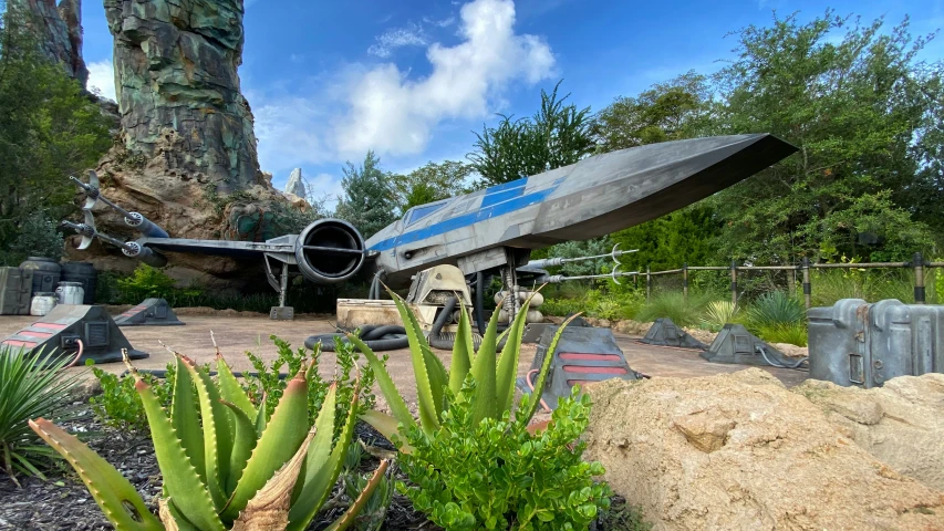 a small airplane sits on display in a rock and grass covered area