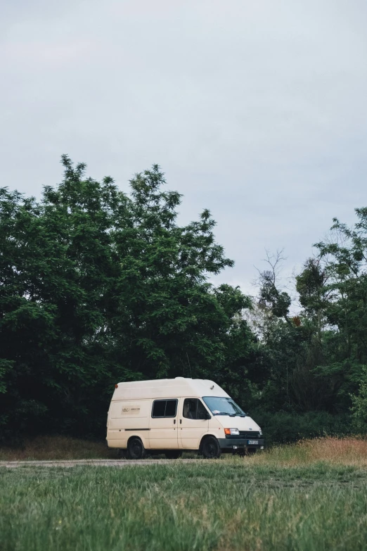 a van parked on the side of the road with trees in the background