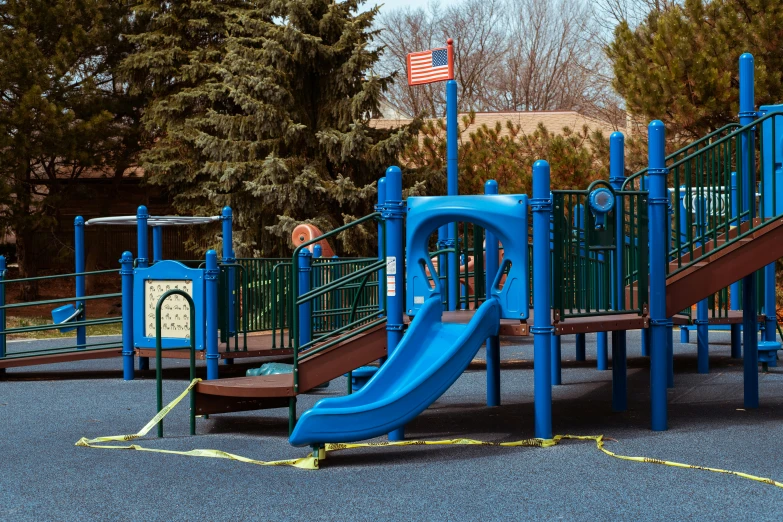 playground with blue and orange play equipment and trees